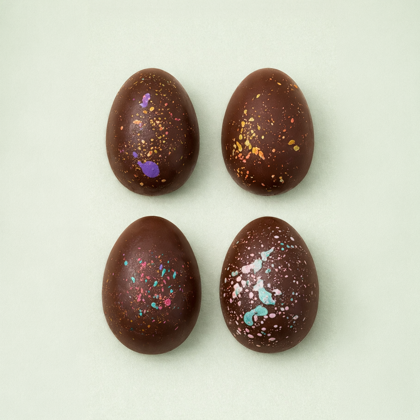 Hand painted milk chocolate Easter eggs with colorful splashes
